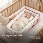 Nouveau-né emmailloté au repos sur le dos, la main d’un parent sur le bord : Réducteur De Lit - Douceur Animale