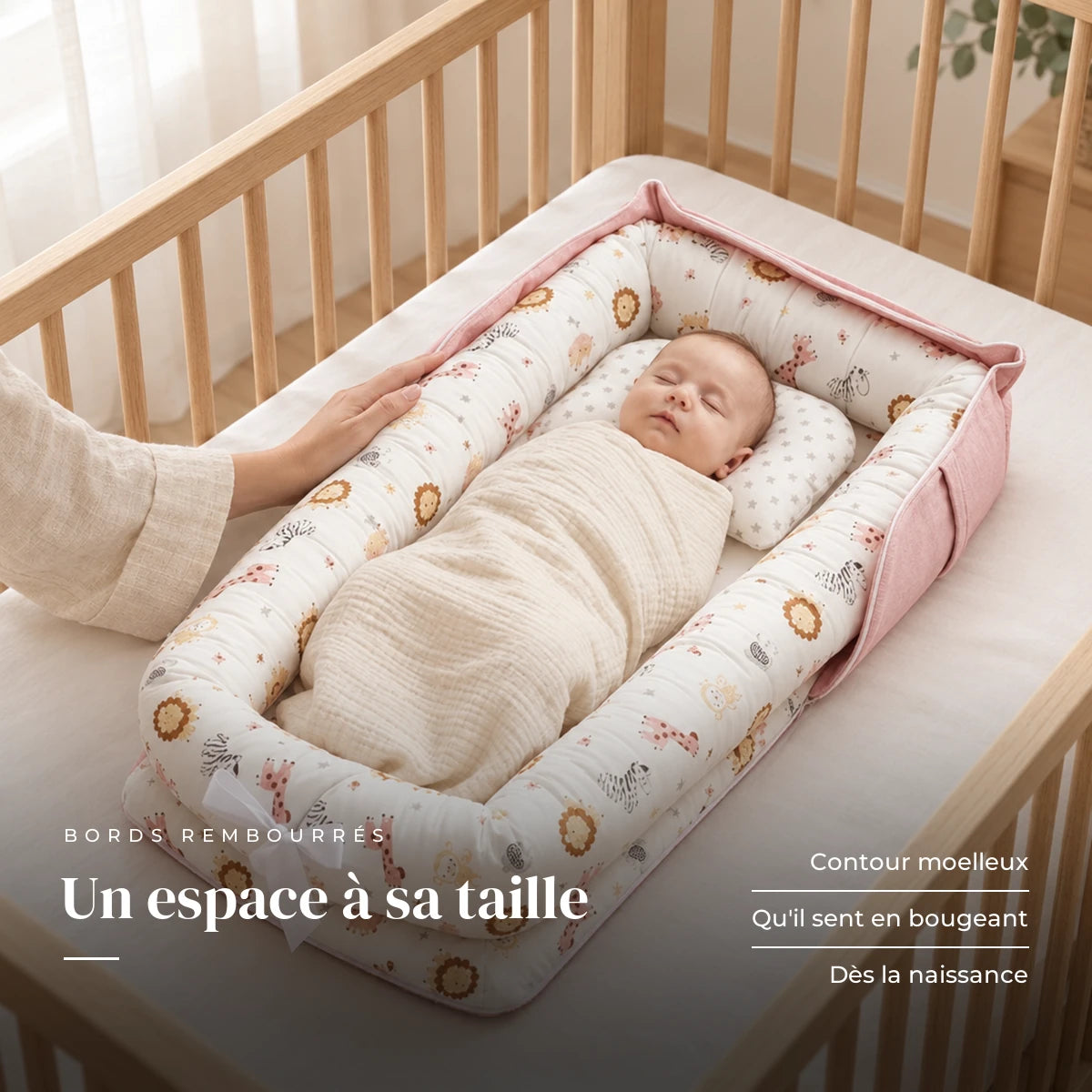 Nouveau-né emmailloté au repos sur le dos, la main d’un parent sur le bord : Réducteur De Lit - Douceur Animale