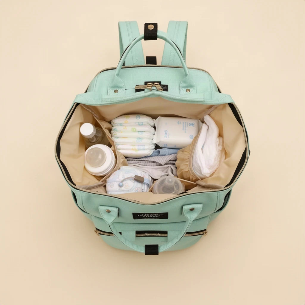 Sac à dos à langer compact avec poches isothermes ouvert et rempli, vu de dessus