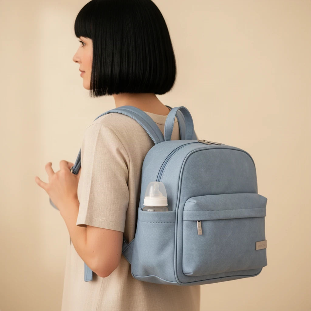 Sac à dos à langer compact effet cuir porté sur le dos, vu de profil
