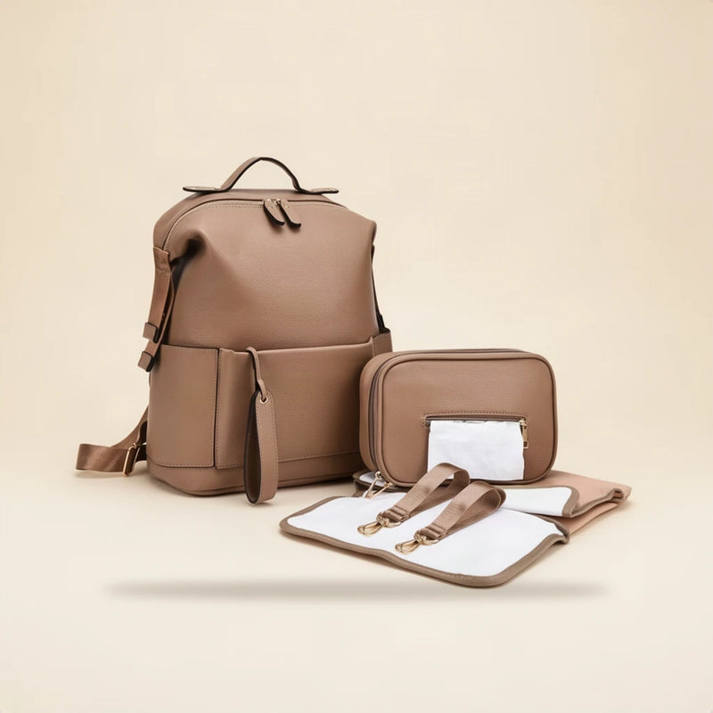 Sac à dos à langer en simili cuir avec matelas et pochette sur fond clair