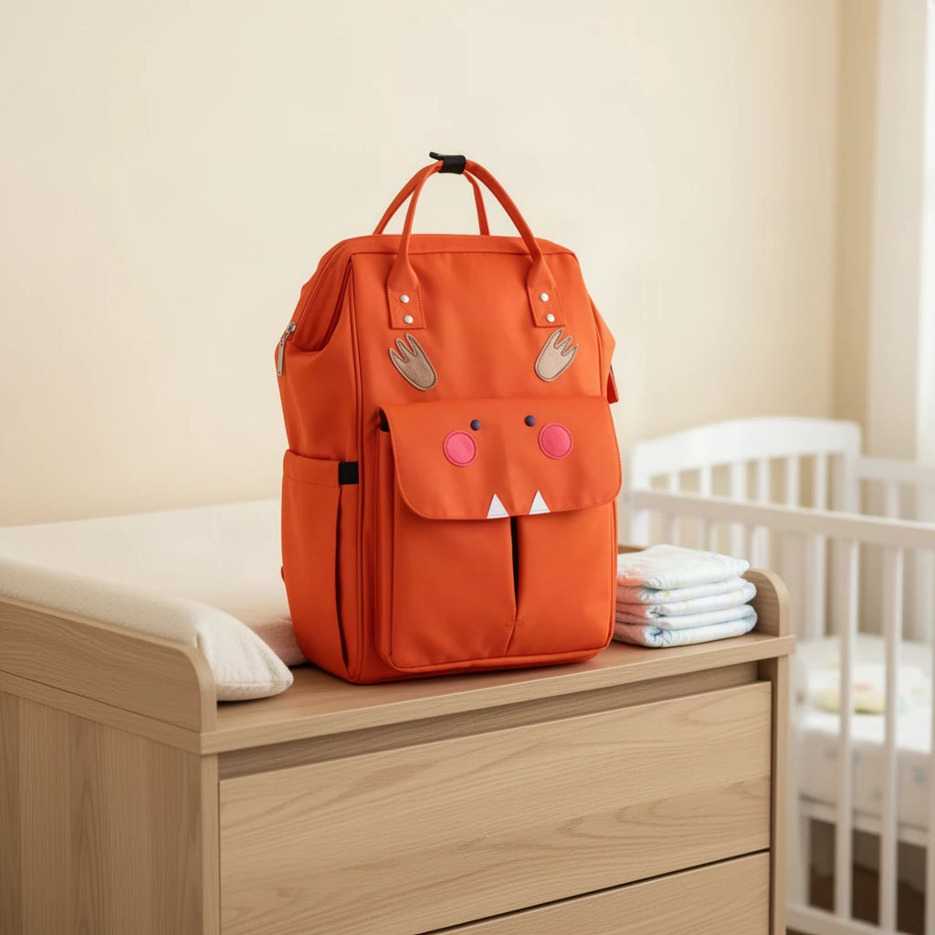 Sac à dos à langer motifs animaux avec attaches poussette posé sur une commode à langer