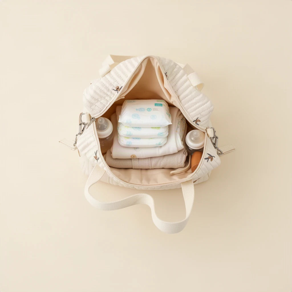 Sac à langer cabas en coton matelassé brodé ouvert et rempli, vu de dessus