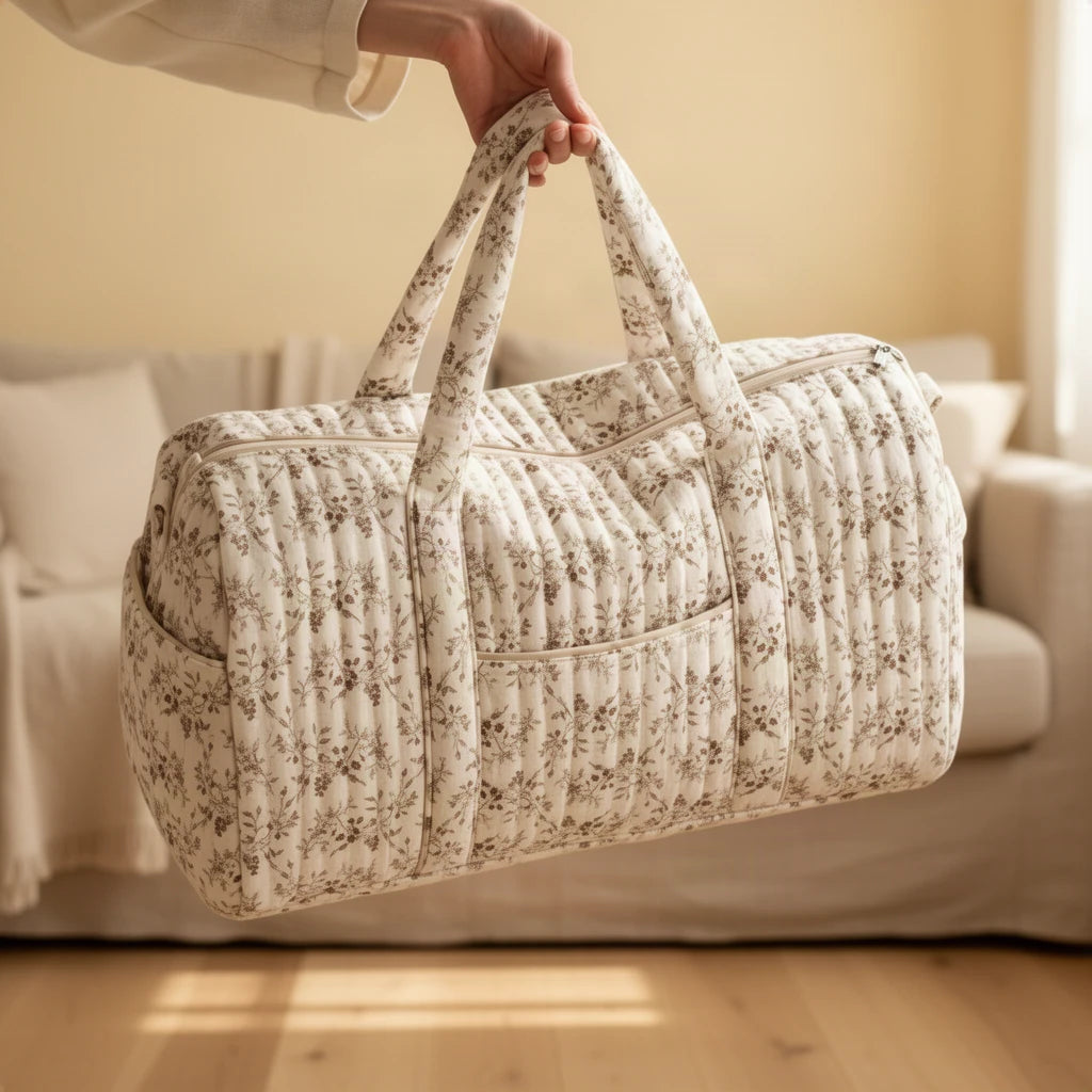 Sac à langer matelassé à fleurs, format week-end tenu à la main