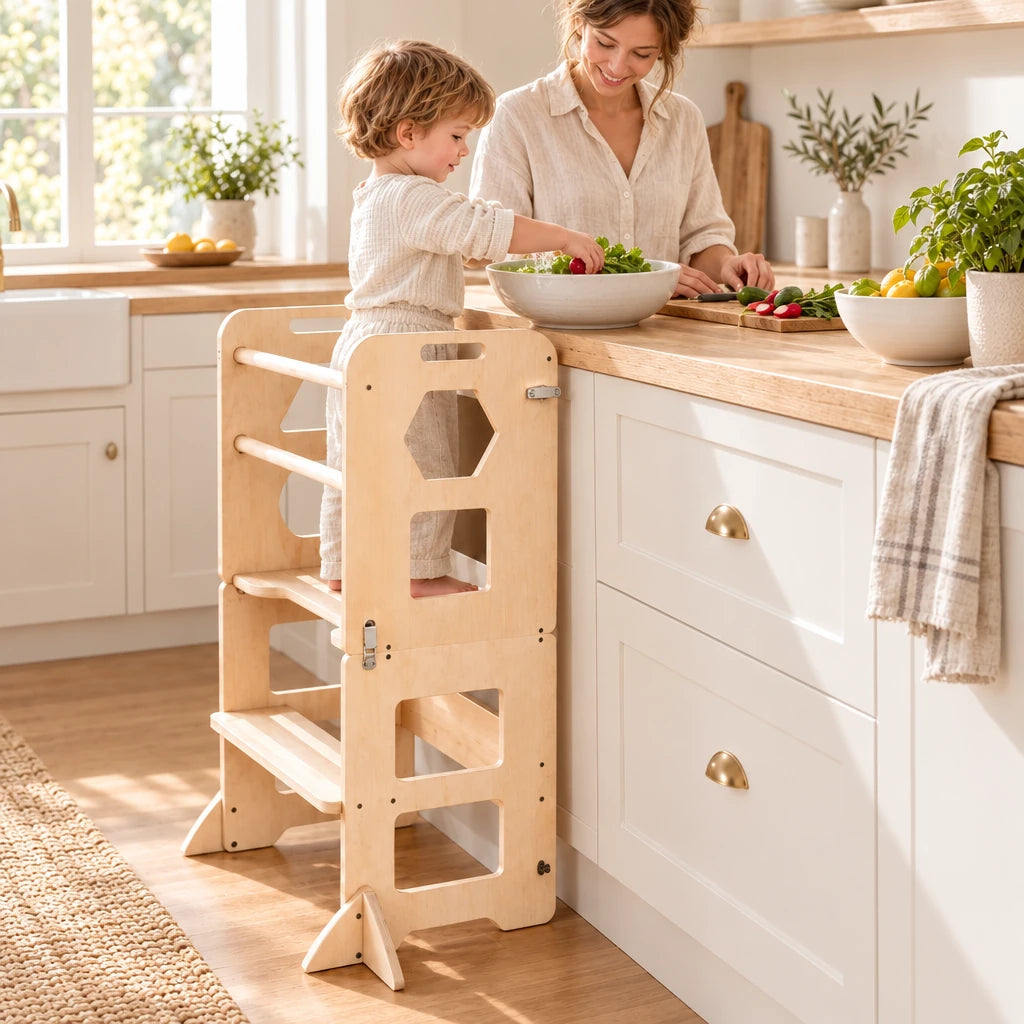 Enfant debout dans la tour d’observation pliante qui aide à cuisiner à côté de sa maman