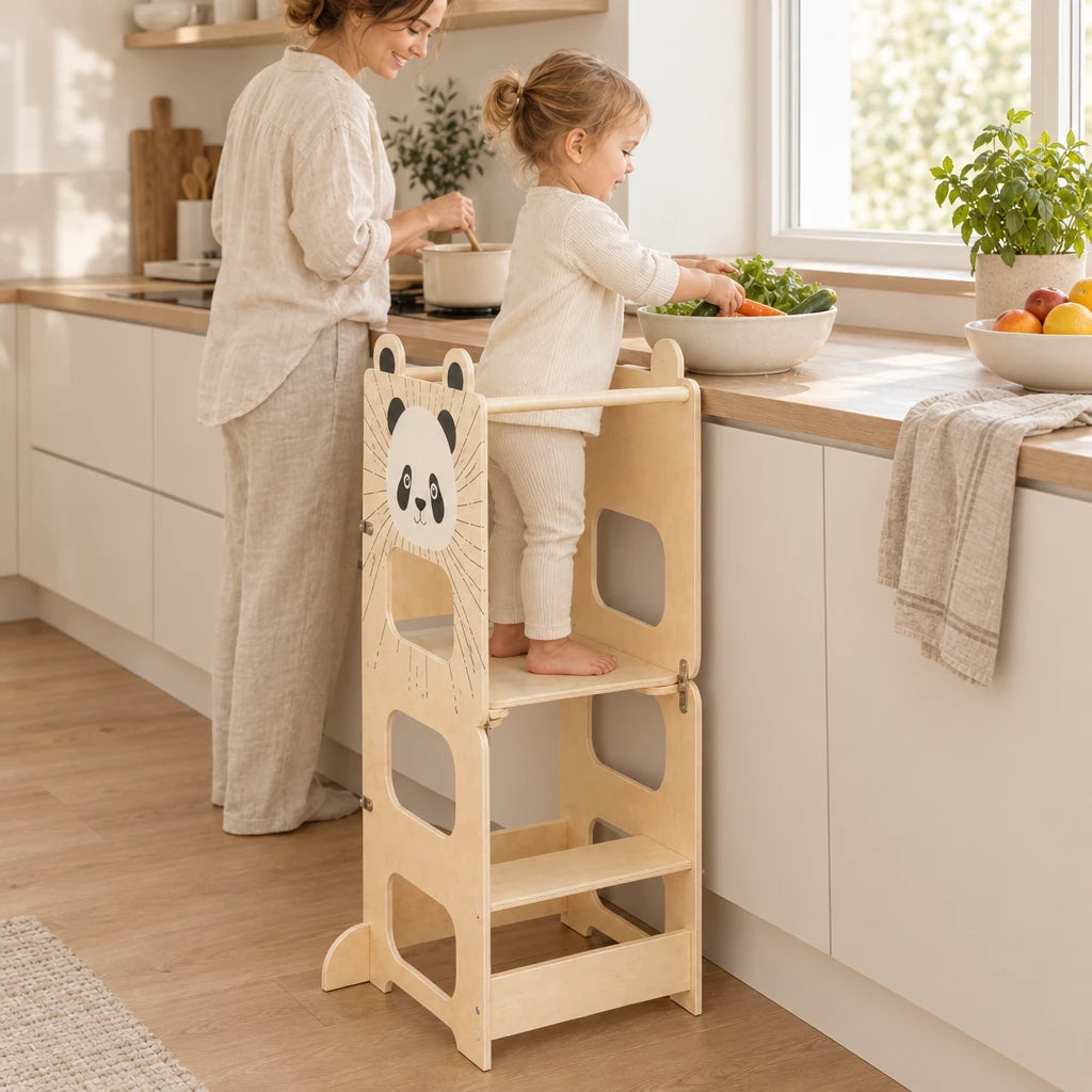 Enfant debout dans la tour montessori qui aide à cuisiner à côté de sa maman