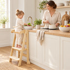 Enfant debout dans la tour montessori pliable qui aide à cuisiner à côté de sa maman