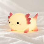 Veilleuse axolotl rechargeable en silicone en gros plan sur un drap blanc
