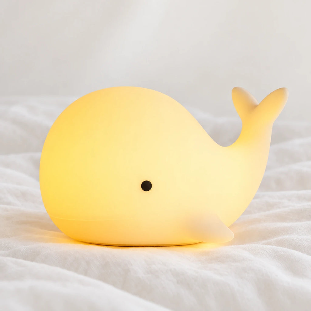 Veilleuse baleine bébé en silicone en gros plan sur un drap blanc