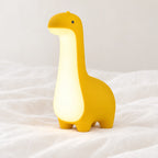 Veilleuse dinosaure bébé en gros plan sur un drap blanc