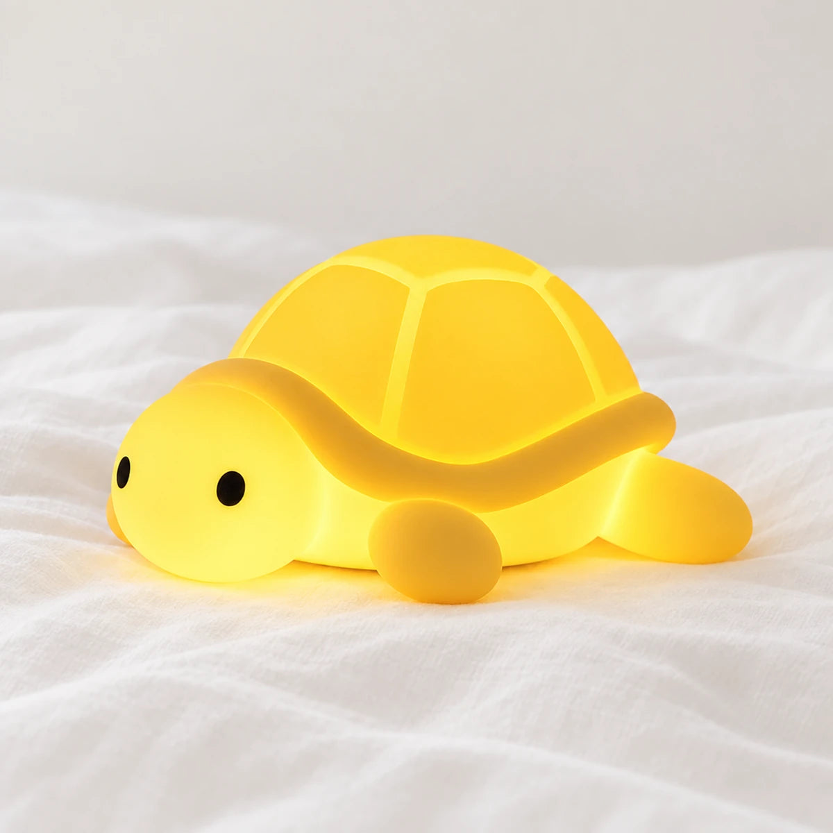Veilleuse tortue bébé en silicone en gros plan sur un drap blanc