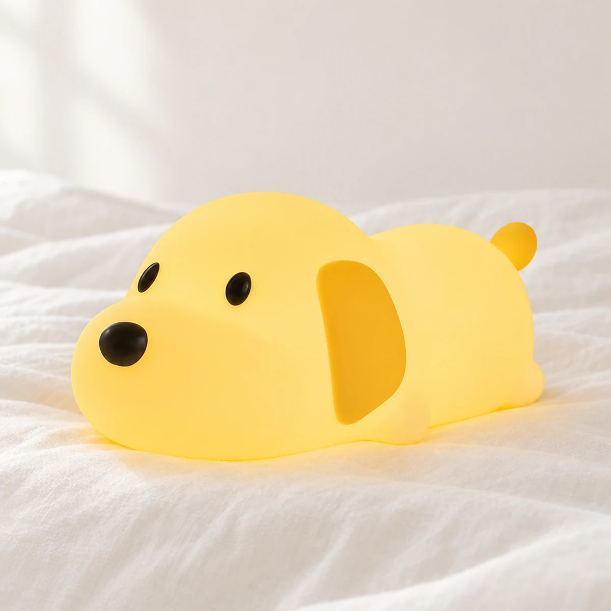 Veilleuse chien bébé en silicone en gros plan sur un drap blanc
