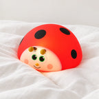 Veilleuse coccinelle rouge tactile en gros plan sur un drap blanc