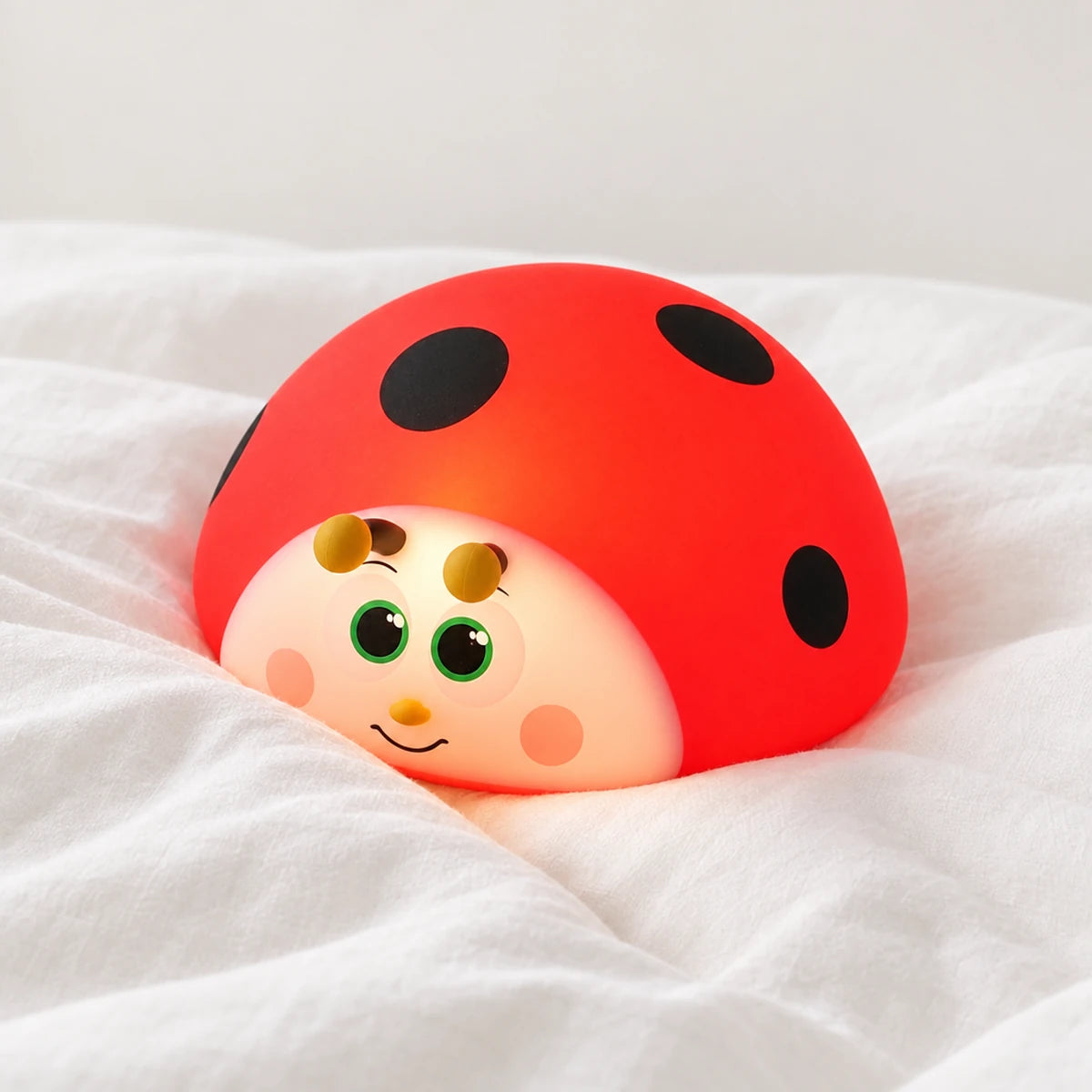 Veilleuse coccinelle rouge tactile en gros plan sur un drap blanc