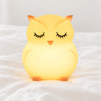 Veilleuse hibou bébé en silicone en gros plan sur un drap blanc