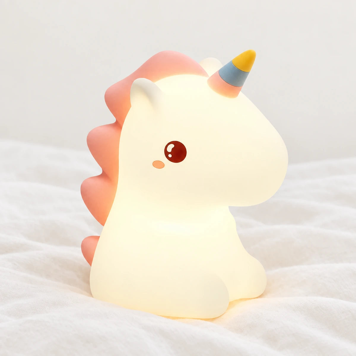 Veilleuse licorne en silicone en gros plan sur un drap blanc