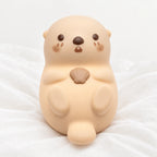Veilleuse loutre en silicone rechargeable en gros plan sur un drap blanc