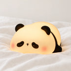 Veilleuse panda en silicone tactile et rechargeable en gros plan sur un drap blanc