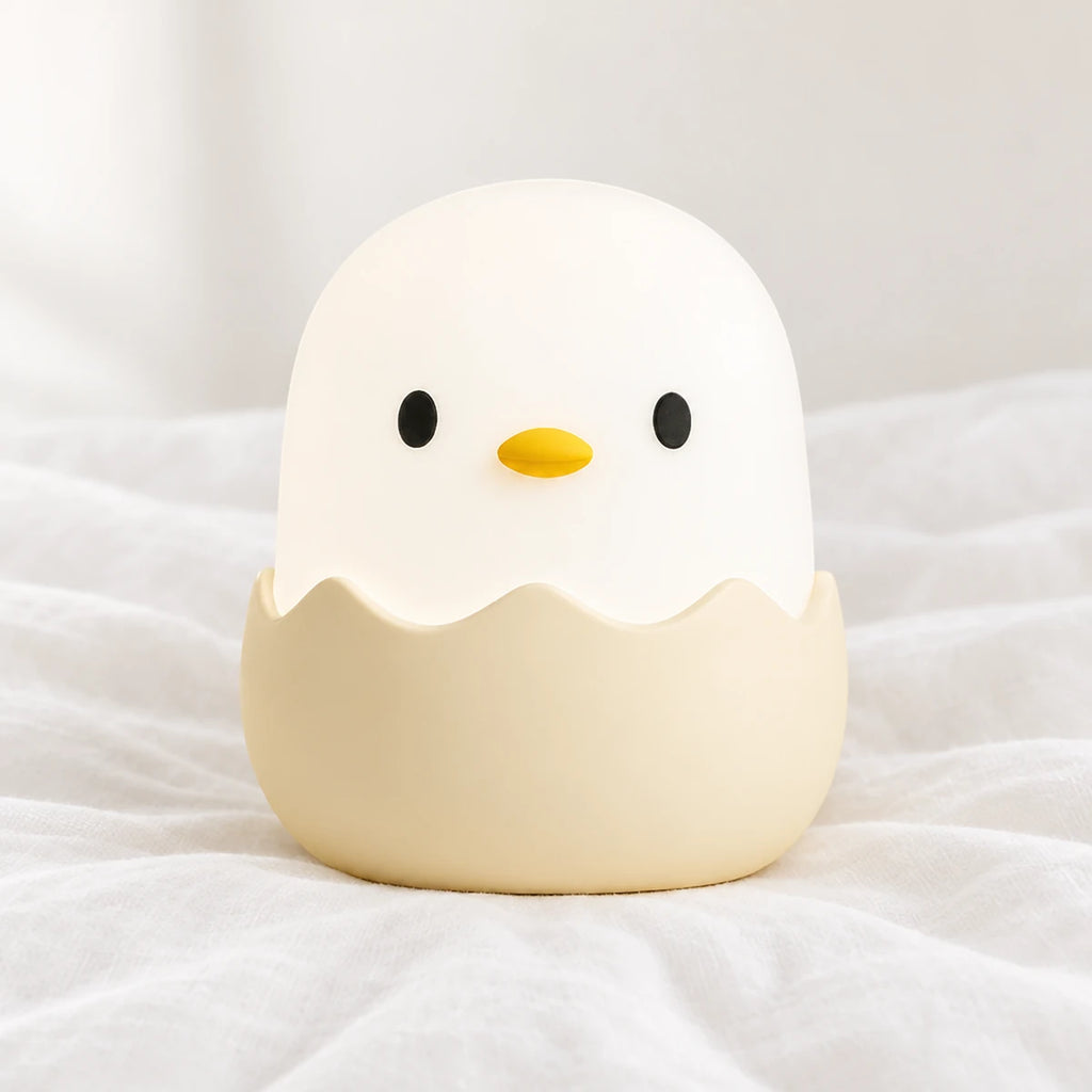 Veilleuse poussin en silicone en gros plan sur un drap blanc